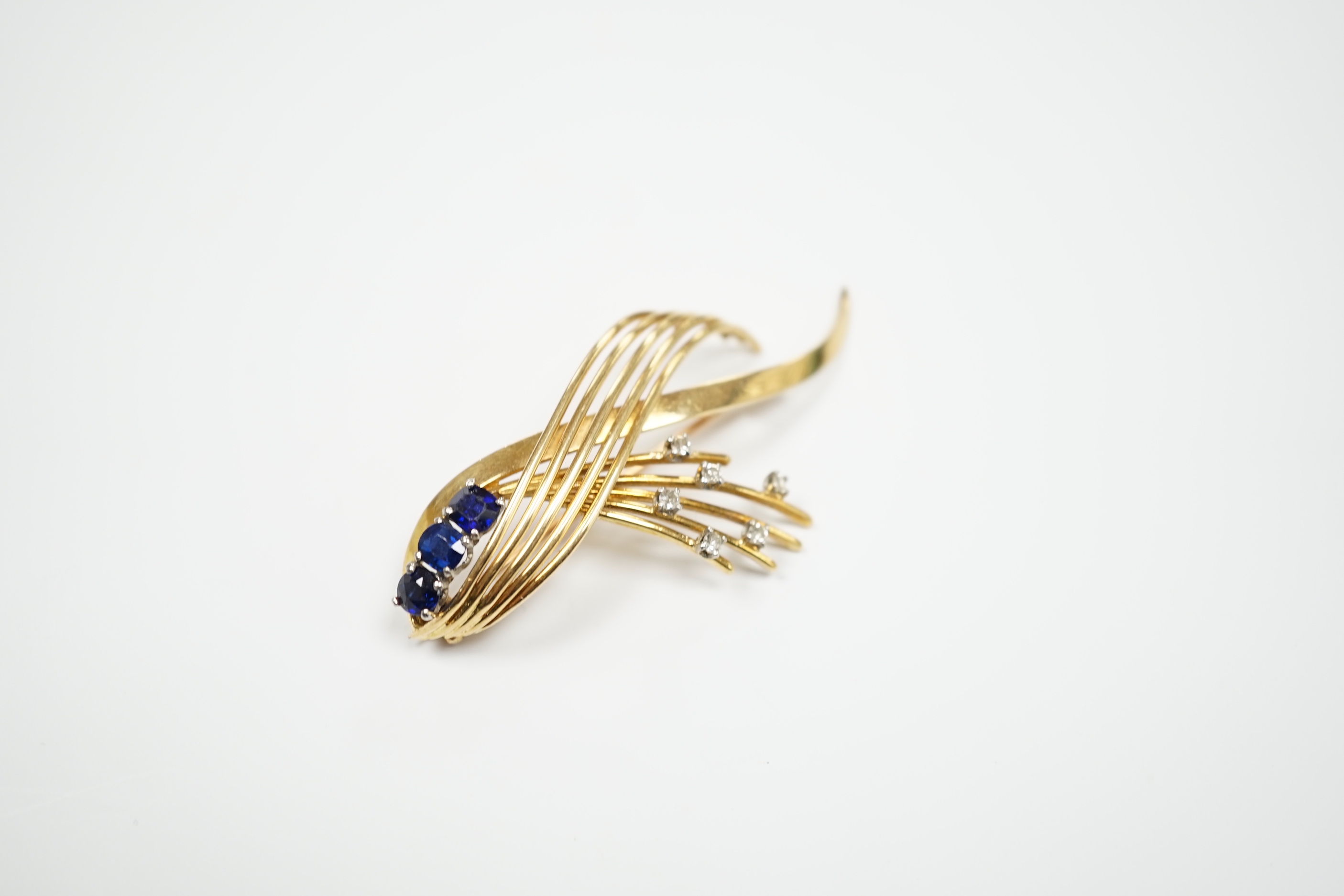 A yellow metal, sapphire and diamond cluster set stylised spray brooch, 52mm, gross weight 9.7 grams.